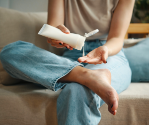 woman applying cream to her feet